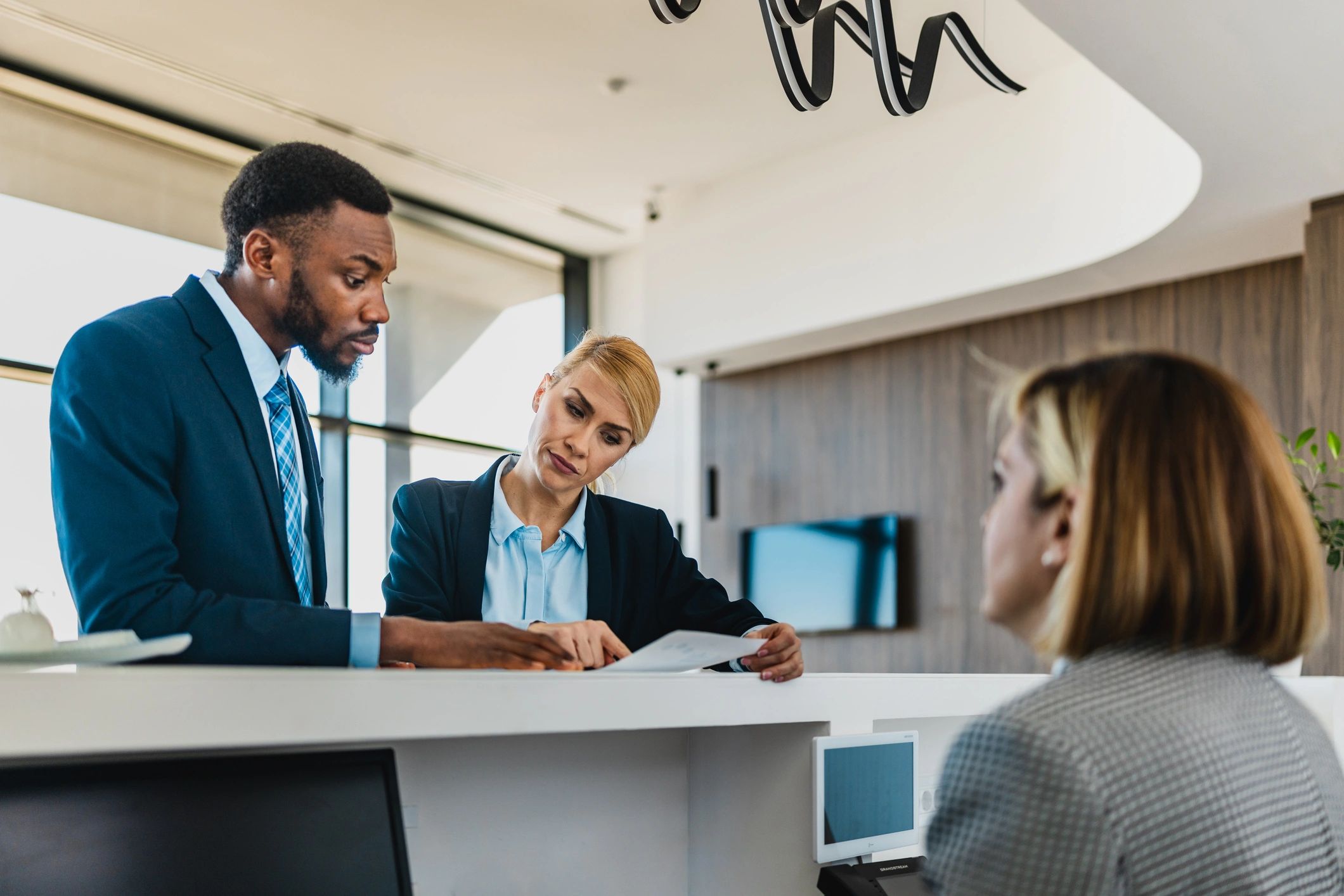Business colleagues discussing documents at a reception desk